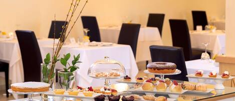 A buffet table with various pastries and desserts.