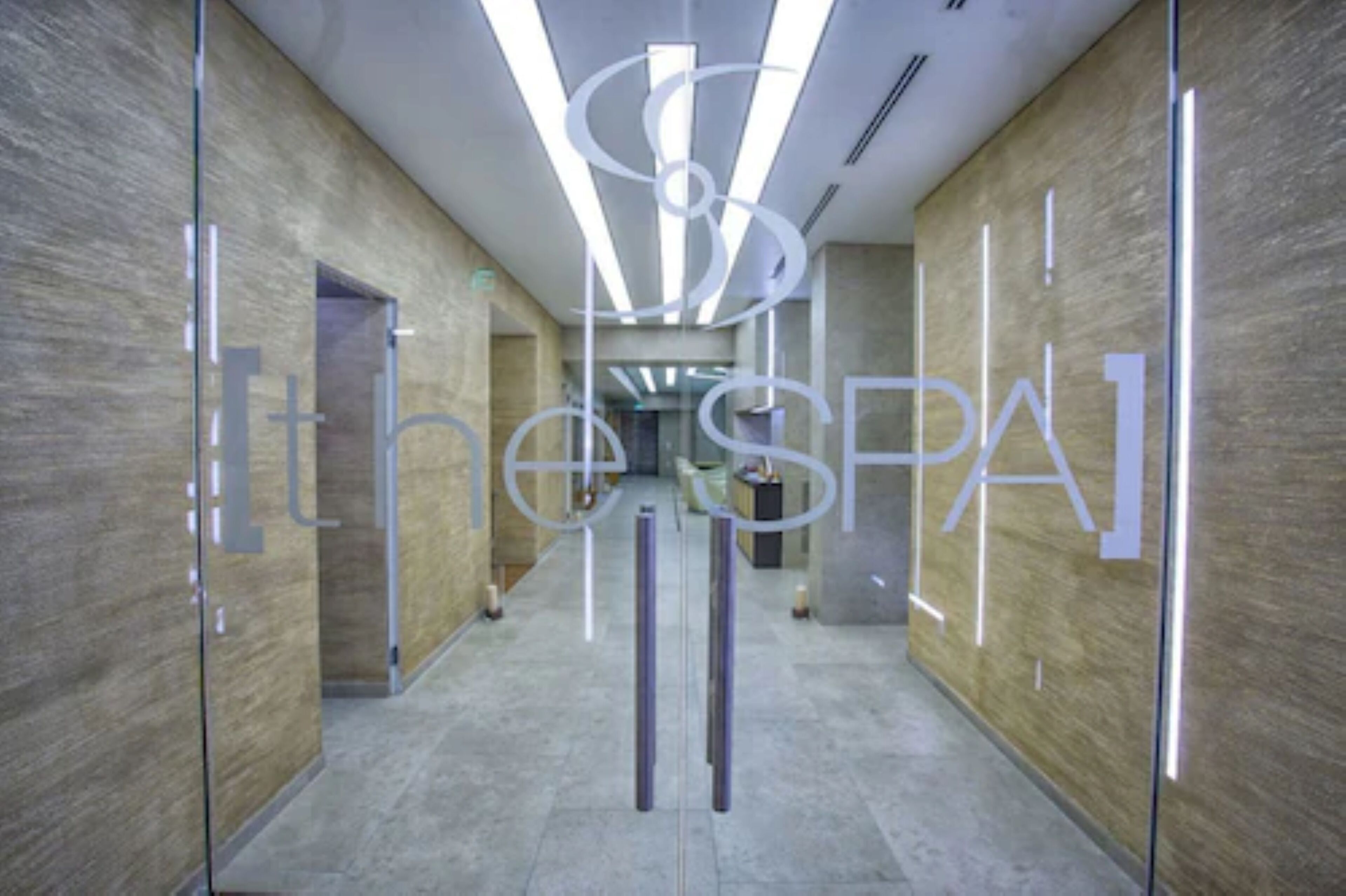 A modern hallway with a central light fixture and a sign reading "the SPA".