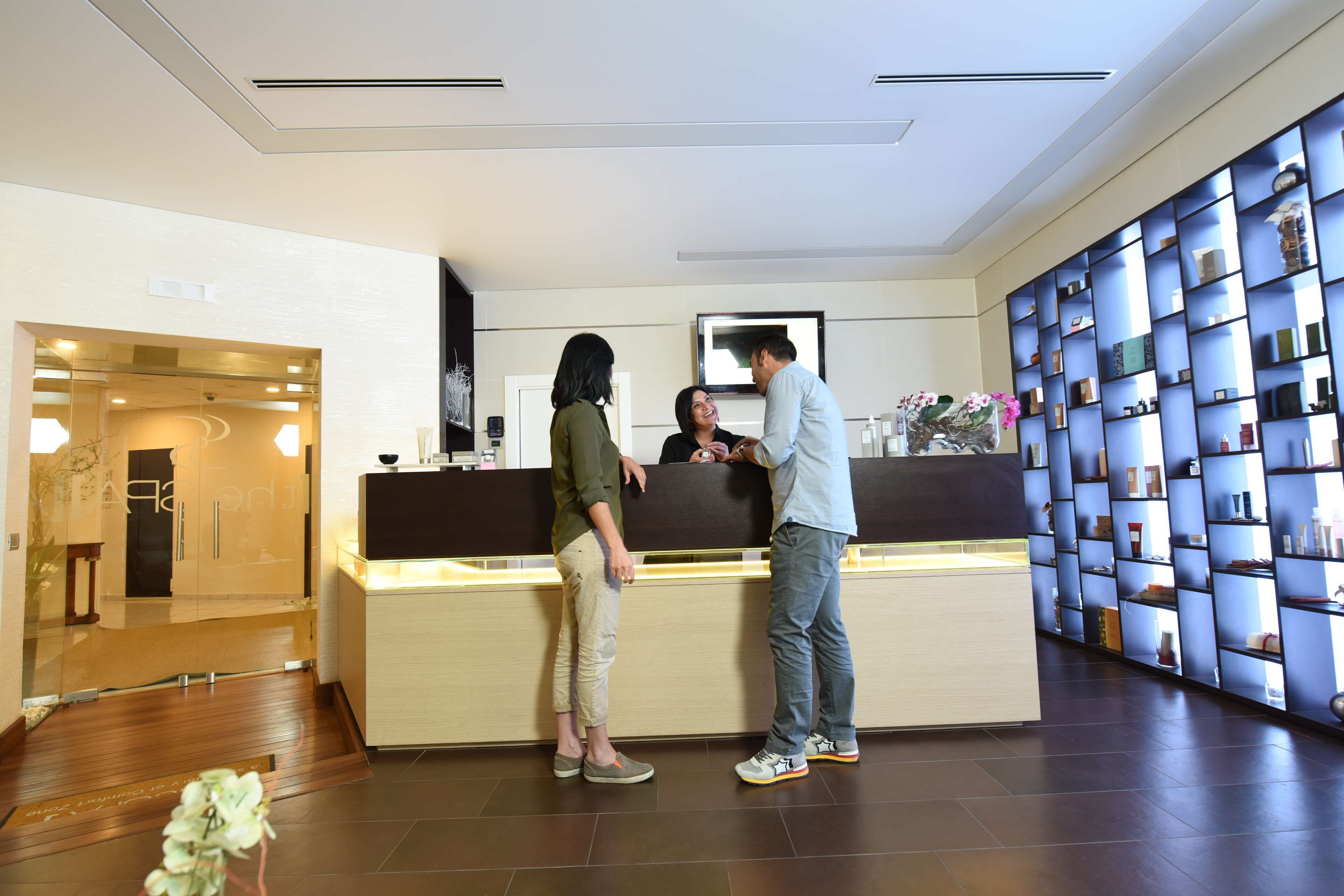 A reception area with a counter, a blue shelving unit with items, and a wooden floor.