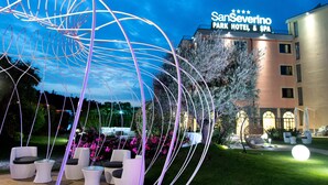 Un hotel con asientos al aire libre e instalación de luces decorativas.