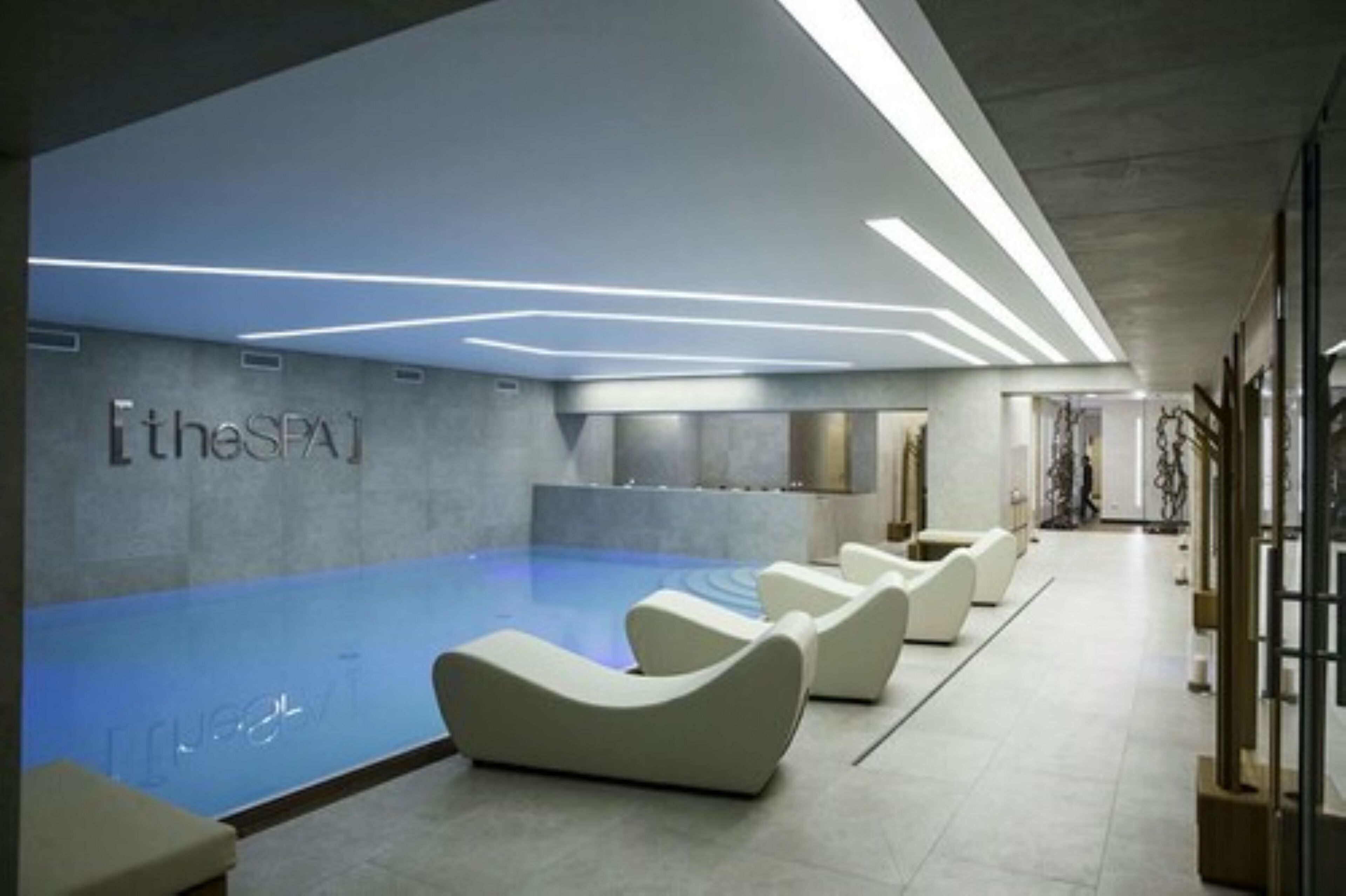 A modern spa area with a pool, reclining chairs, and a sign reading "theSPA1".