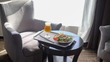 A dining area with a table set for a meal, a glass of orange juice, and a plate of salad.