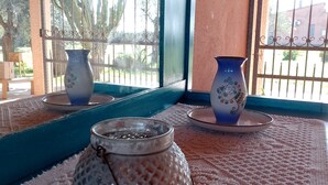 A room with a view through barred windows, featuring two decorative vases on a patterned tablecloth. - CuccuruAio' B&B (Siamaggiore)