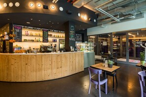 A modern cafe with a wooden counter, seating area, and visible menu boards. - Generator Berlin Mitte (Berlin)