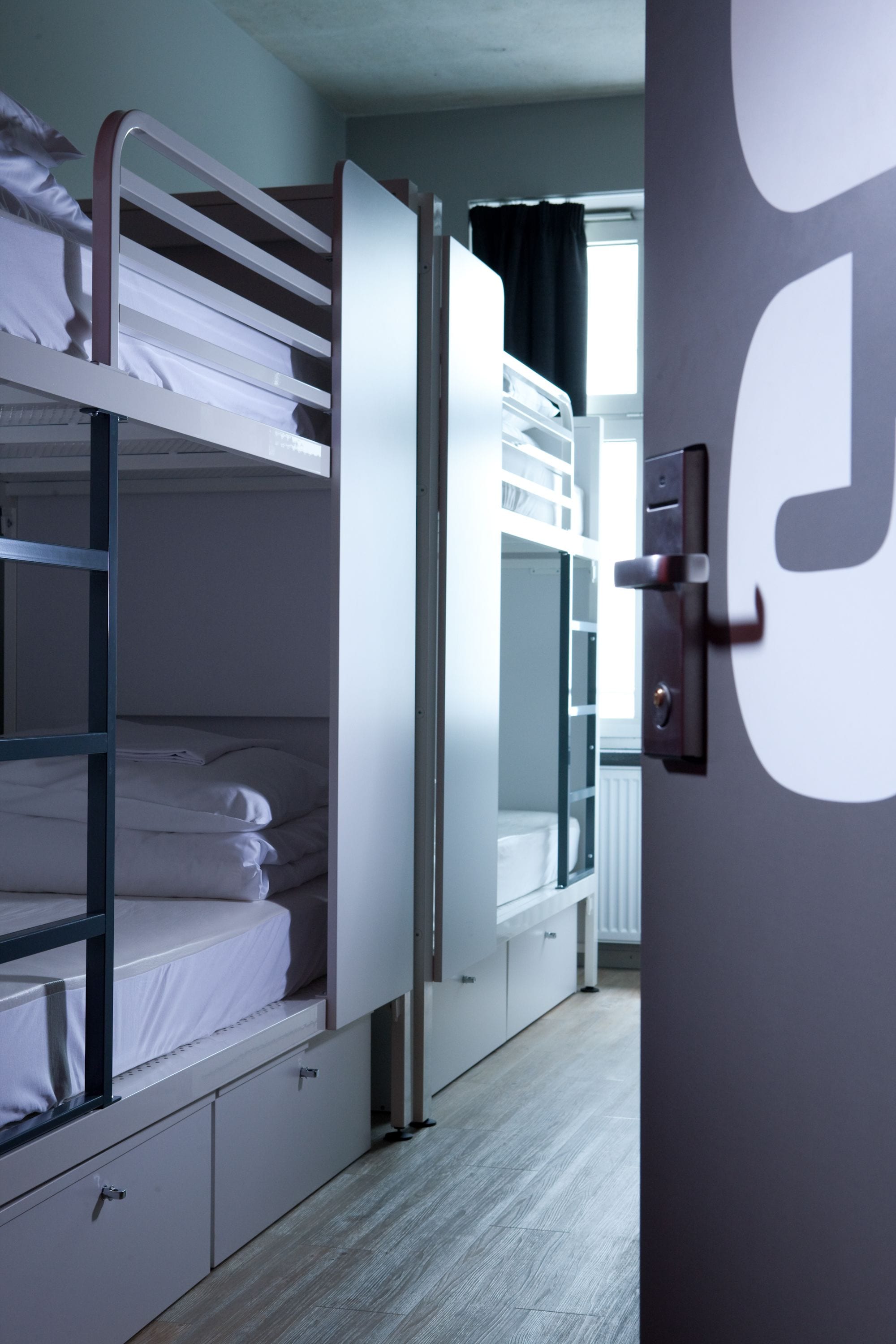 Dormitorio con literas, una puerta y un radiador.