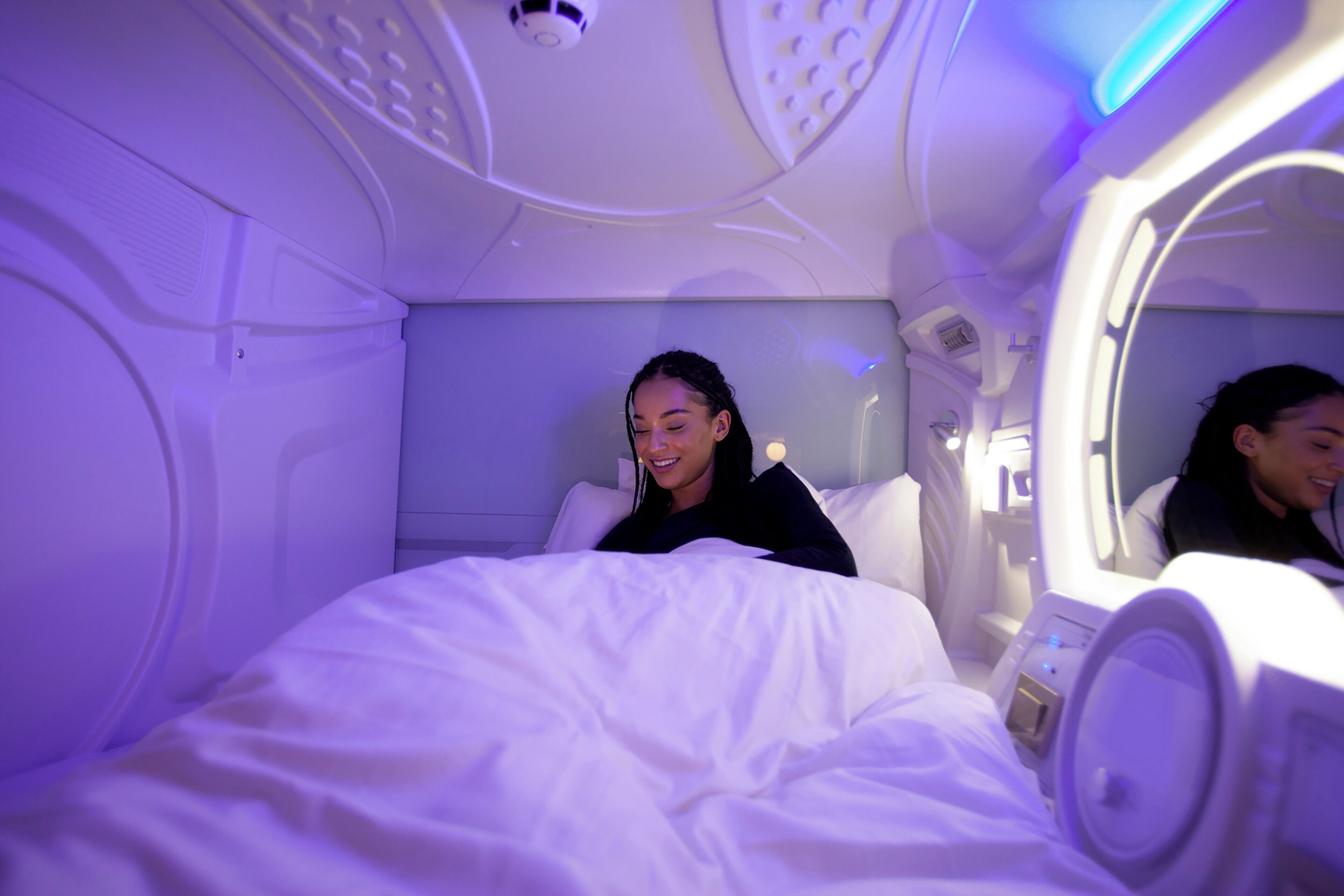 A room with a bed, a mirror, and a control panel.