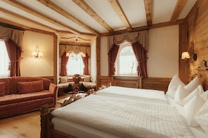 Una habitación de madera con una cama, un sofá y una mesa con sillas.