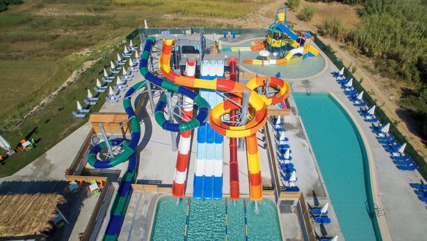 Un parque acuático con varias toboganes y una zona de piscina.