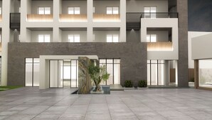 Un edificio moderno con un amplio patio, ventanas grandes y una fuente central.