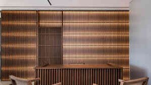 A room with a central seating area and a patterned wall. - Selini Suites (Platanias)