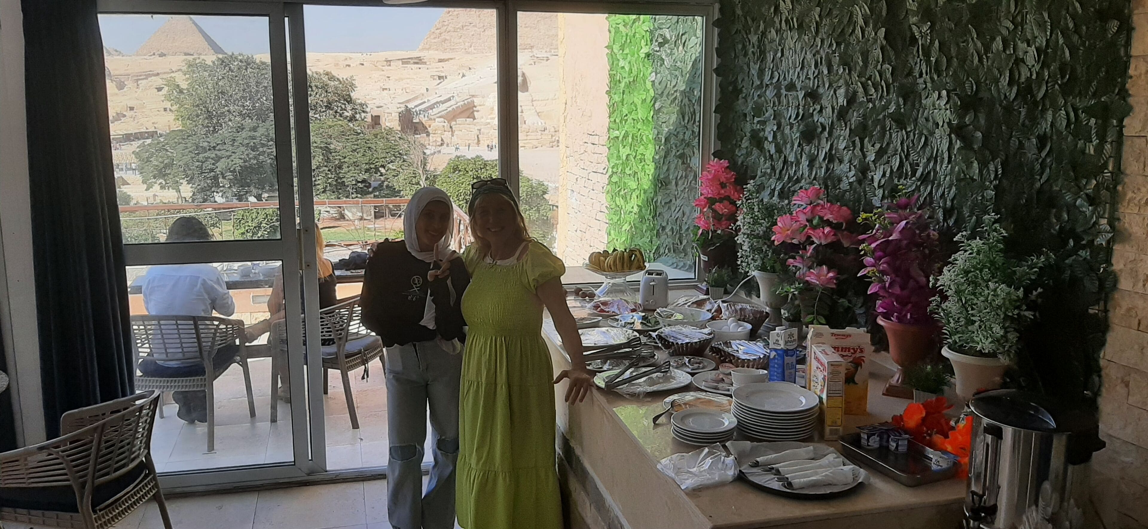 A restaurant with a view of a pyramid and a green wall.