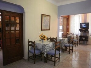 Comedor con una mesa dispuesta para cuatro personas, rodeado de sillas de madera.