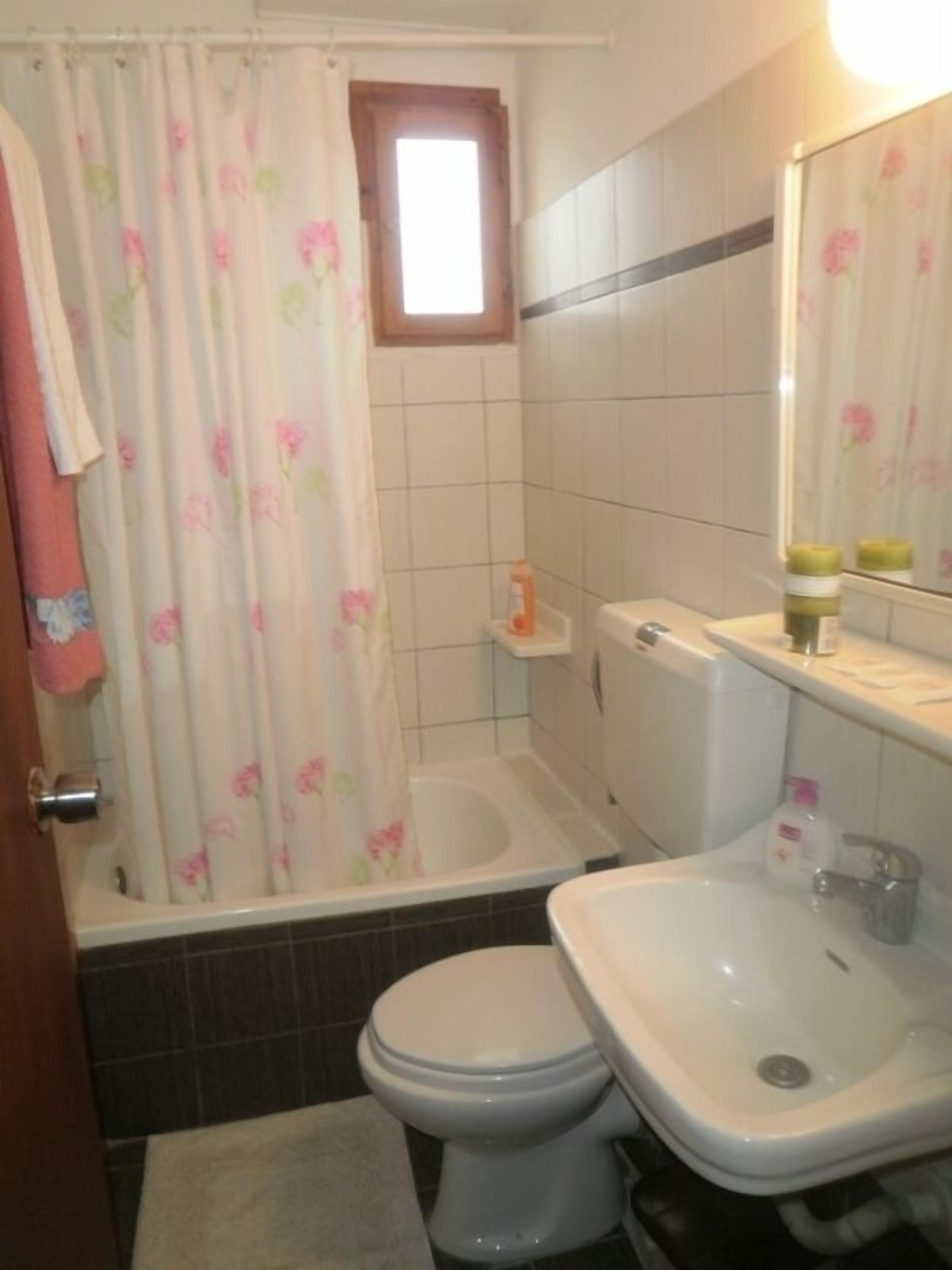 A bathroom with a toilet, sink, and bathtub.