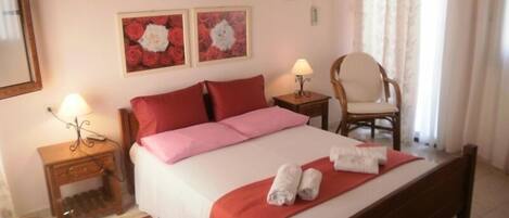 A hotel room with a bed, two bedside tables, a chair, and two wall-mounted lamps.