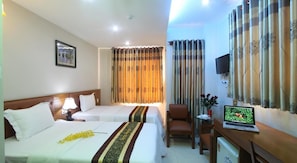 A hotel room with two beds, a desk with a laptop, a chair, a TV, and curtains. - RedDoorz near Gia Dinh Park (Ho Chi Minh City)