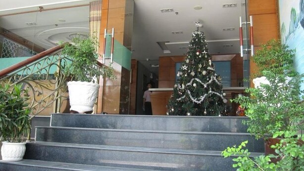 A staircase leading to a lobby with a Christmas tree and potted plants. - RedDoorz near Gia Dinh Park (Ho Chi Minh City)
