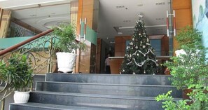 A staircase leading to a lobby with a Christmas tree and potted plants. - RedDoorz near Gia Dinh Park (Ho Chi Minh City)