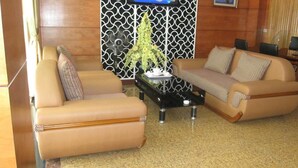 A living room with two sofas, a coffee table, and a decorative plant. - RedDoorz near Gia Dinh Park (Ho Chi Minh City)