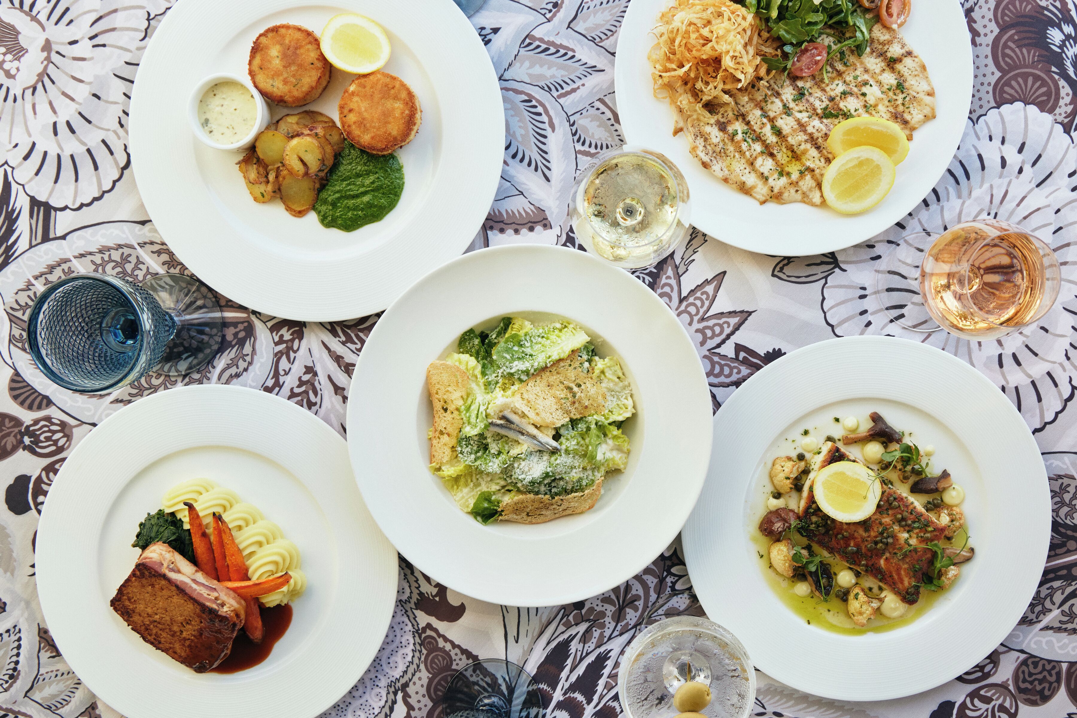 Une table avec quatre assiettes remplies de nourriture, chacune contenant des plats et des accompagnements différents.