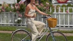 Une personne à vélo, avec un panier fixé sur le porte-bagages, circule sur une route.