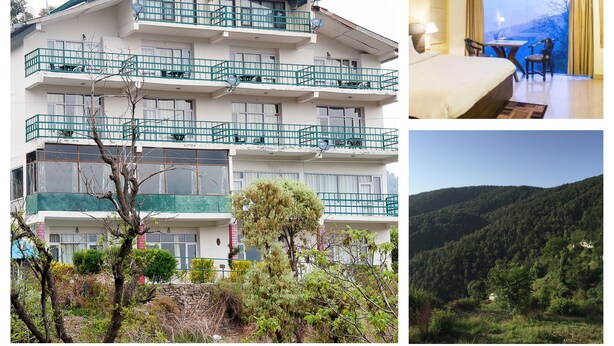 A multi-story hotel with balconies, a bedroom with a view, and a mountainous landscape. - The Ayali Fernhill Resort, Chail (Kandaghat)