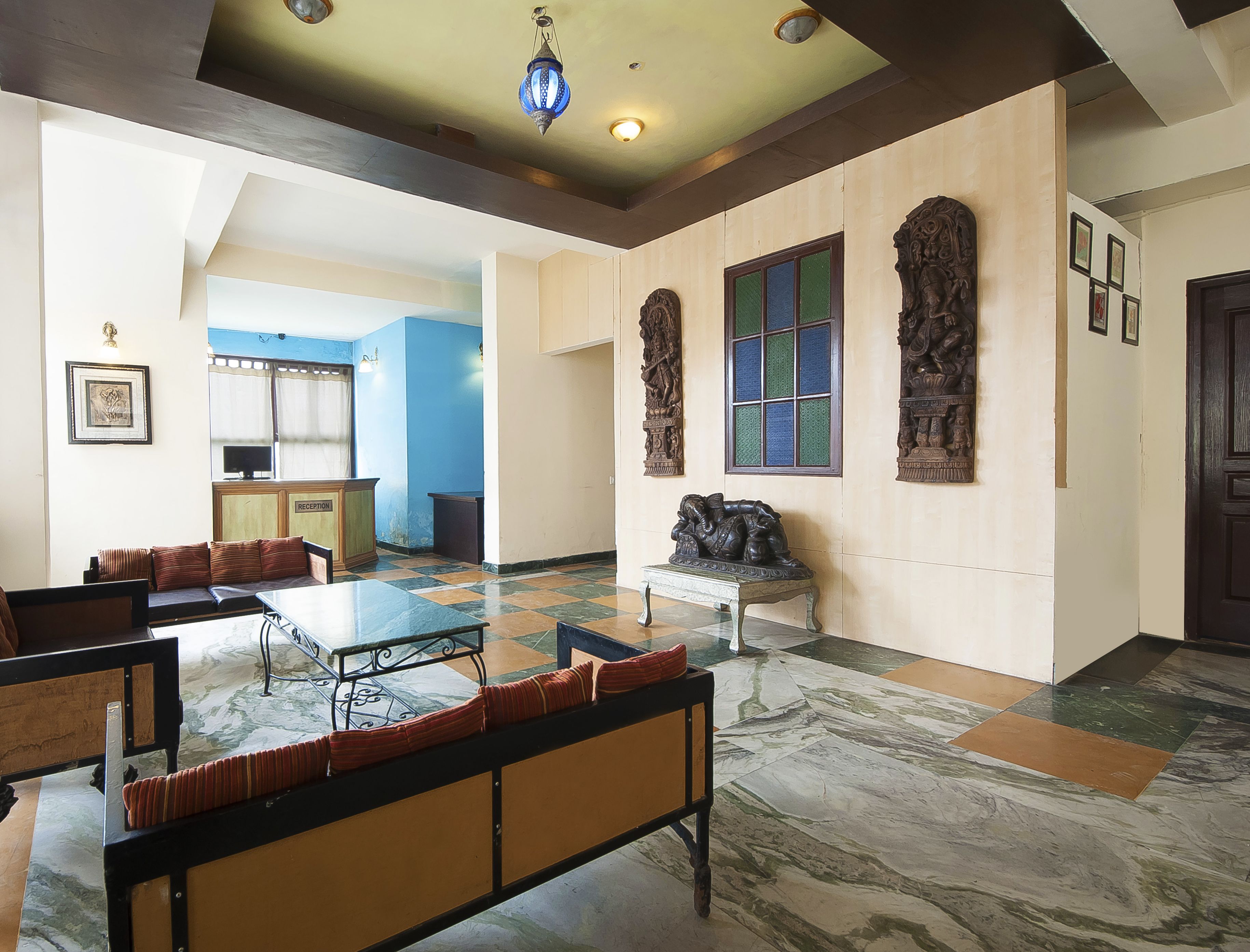 A spacious lobby with a reception desk, seating area, and decorative wall panels.