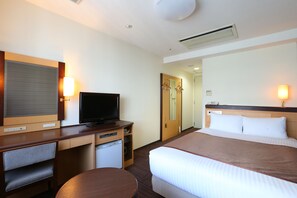 A hotel room with a bed, a desk with a television, a small refrigerator, and a mirror. - Hotel Hokke Club Sapporo (Sapporo)