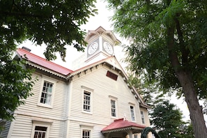 A historic building with a clock tower, large windows, and a red roof.