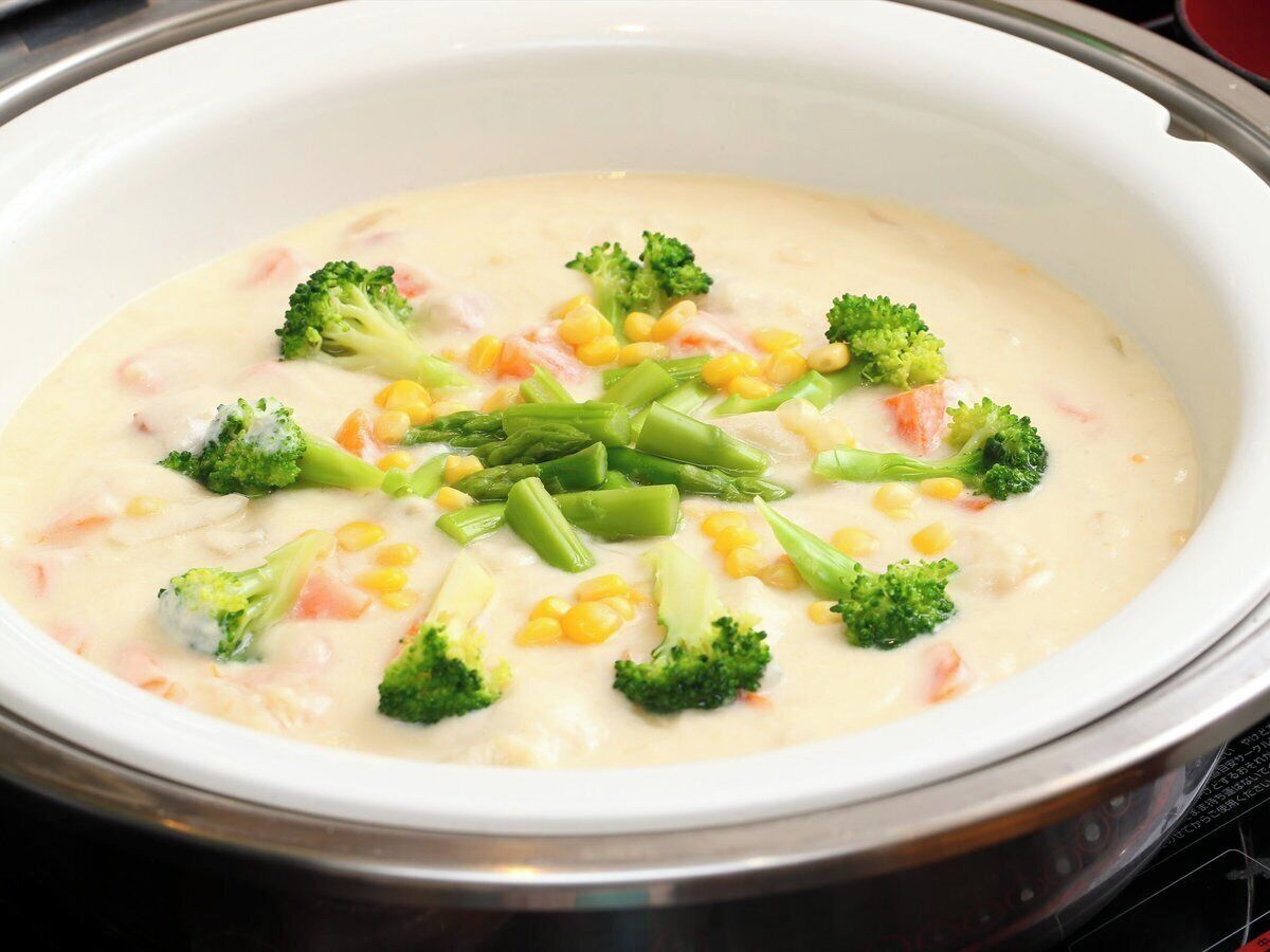 Un tazón blanco con una crema de brócoli y maíz.