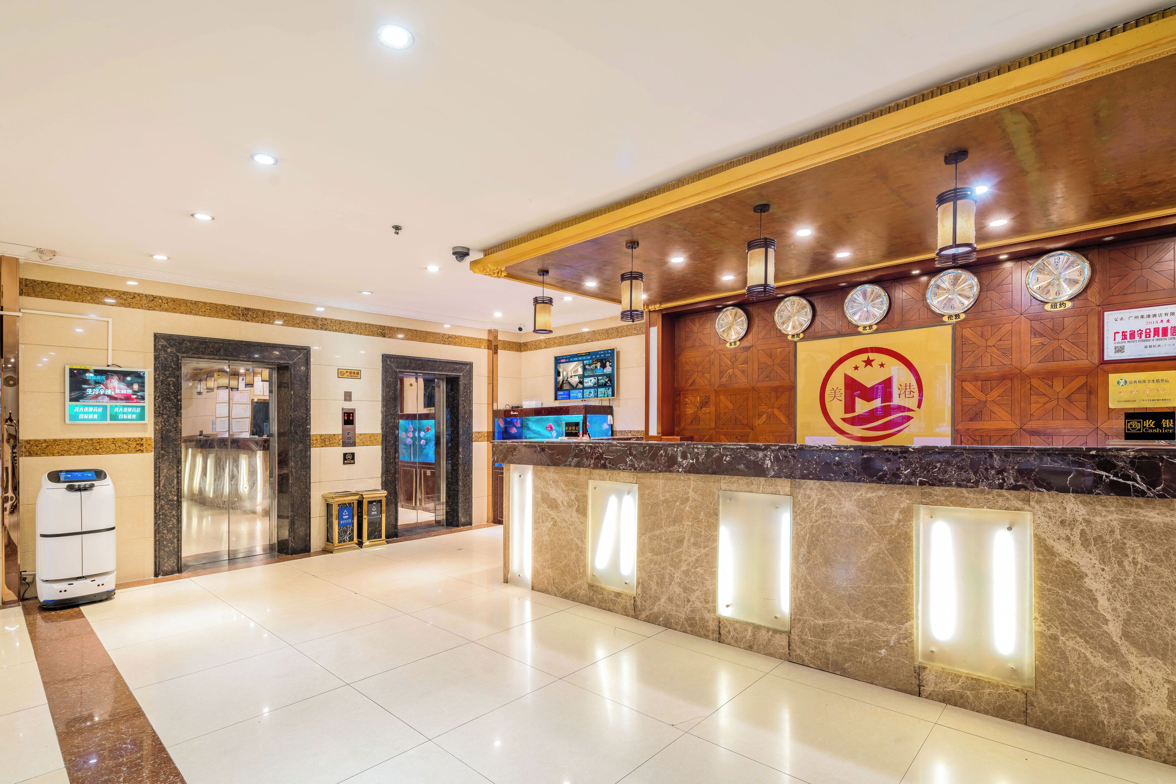 A hotel reception area with a marble counter, a digital clock, and a sign with a logo.