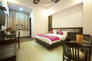 A neatly arranged bedroom with a bed, bedside table, and a small seating area with a chair and table.