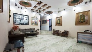Un hall d’entrée spacieux avec un sol en marbre, un canapé, une table basse et un comptoir d’accueil.
