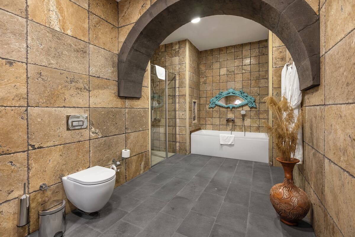 deluxe room (cave) | bathroom | combined shower/bathtub, jetted bath, rainfall showerhead