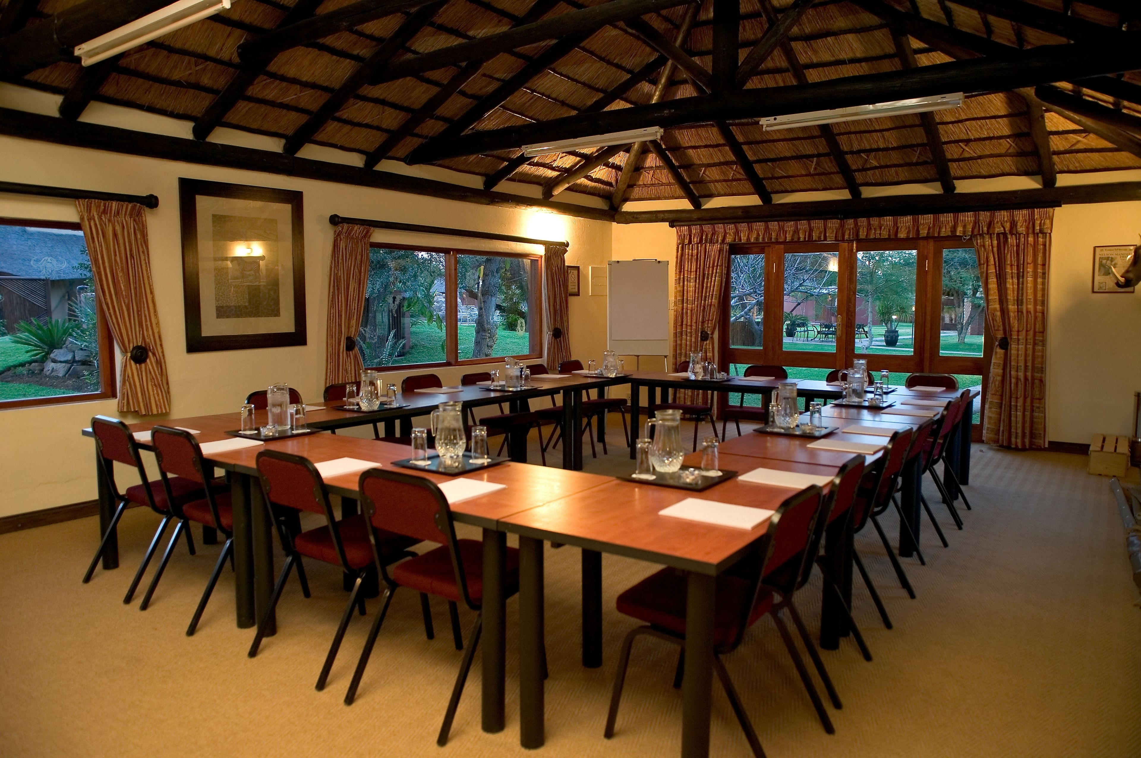 A conference room with a long table, chairs, and large windows.