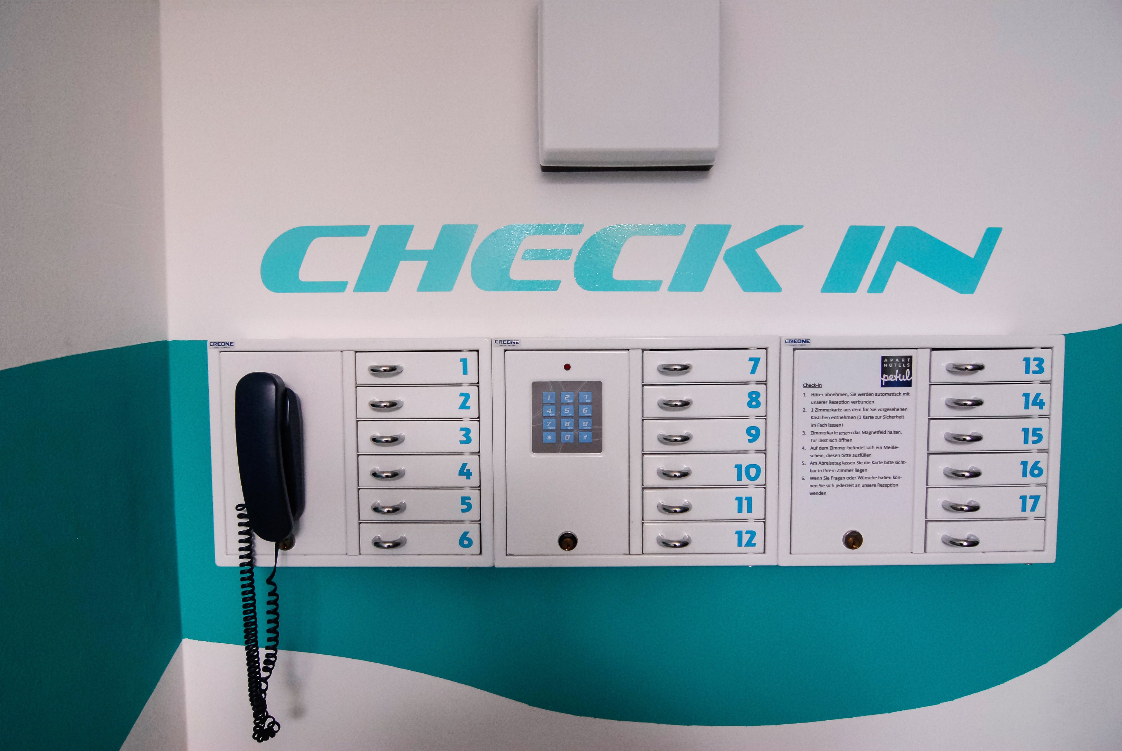 A hotel reception area with a check-in counter, a phone, and a wall-mounted air conditioning unit.