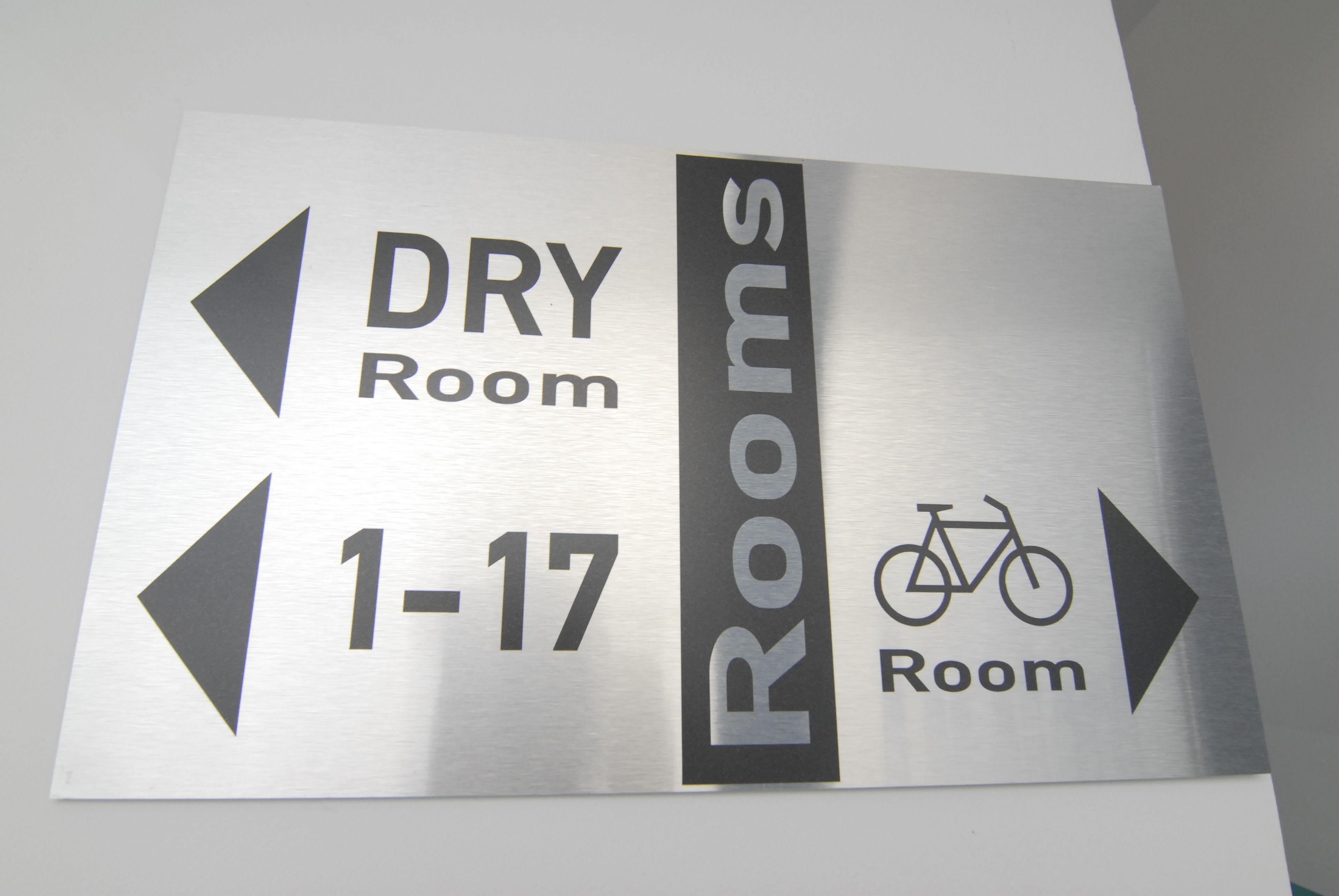 A sign indicating directions to the dry room and rooms 1-17, with a bicycle symbol suggesting bike-friendly accommodations.