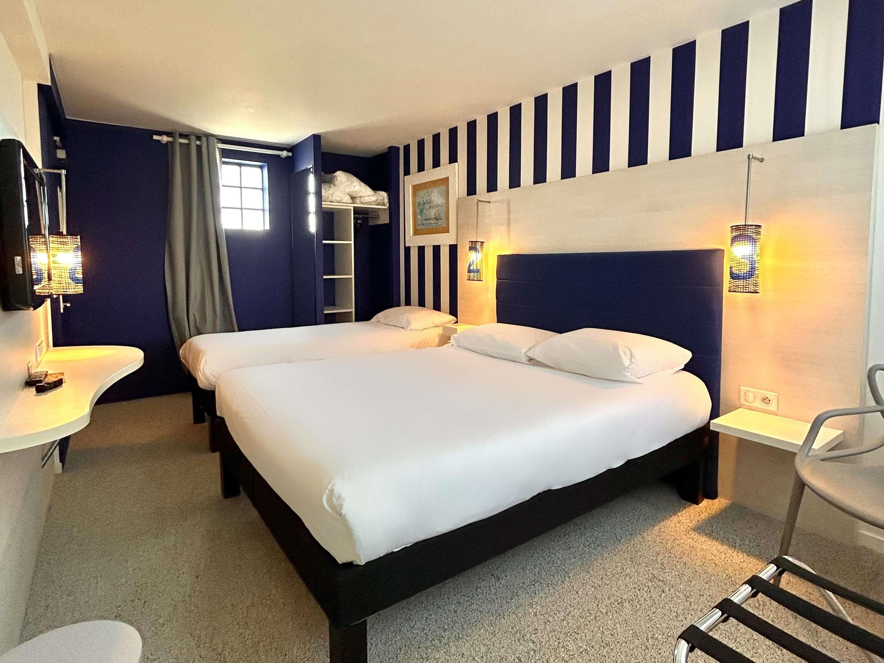 Een hotelkamer met een groot bed, nachtkastjes, een bureau en een stoel.