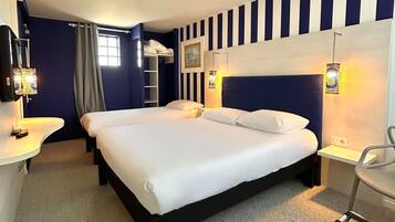 Een hotelkamer met een groot bed, nachtkastjes, een bureau en een stoel.