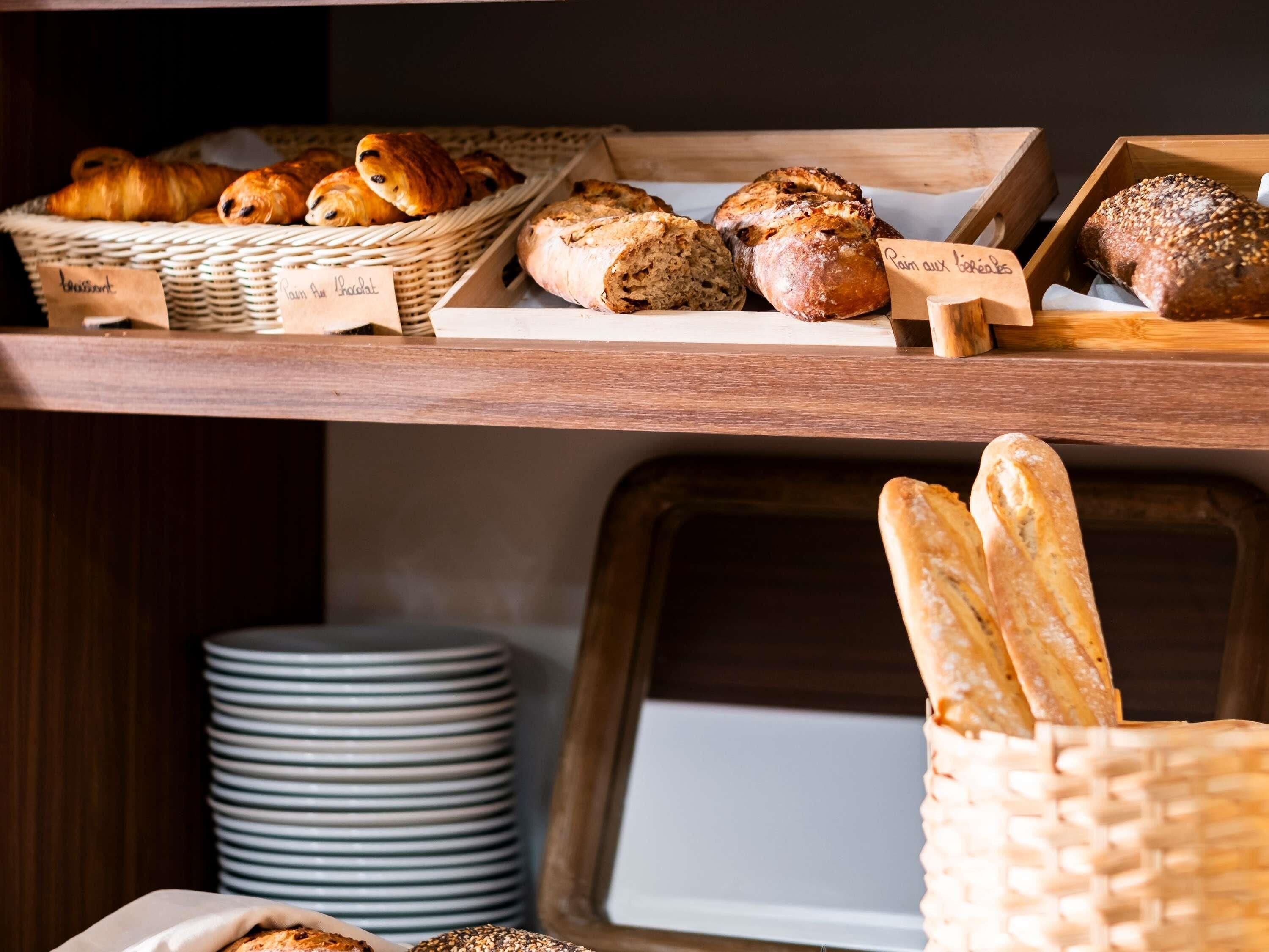 Une vitrine de boulangerie présentant une variété de pains et de pâtisseries.