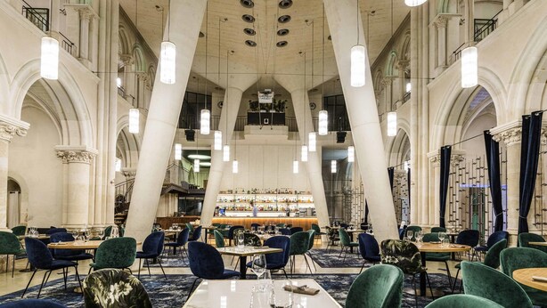A spacious interior with high ceilings, large columns, and modern lighting fixtures.