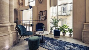 A spacious lobby with high ceilings, large windows, and classical architecture.