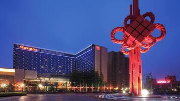 Un hotel Sheraton con una escultura roja distintiva al frente.