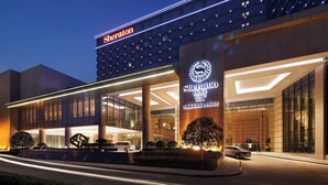 A Sheraton hotel with a modern facade, large glass windows, and illuminated signage. - Sheraton Hefei Xinzhan Hotel (Hefei)