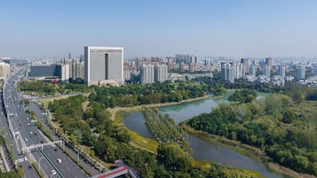 Un paisatge urbà amb un edifici modern destacat, un riu i una autopista.