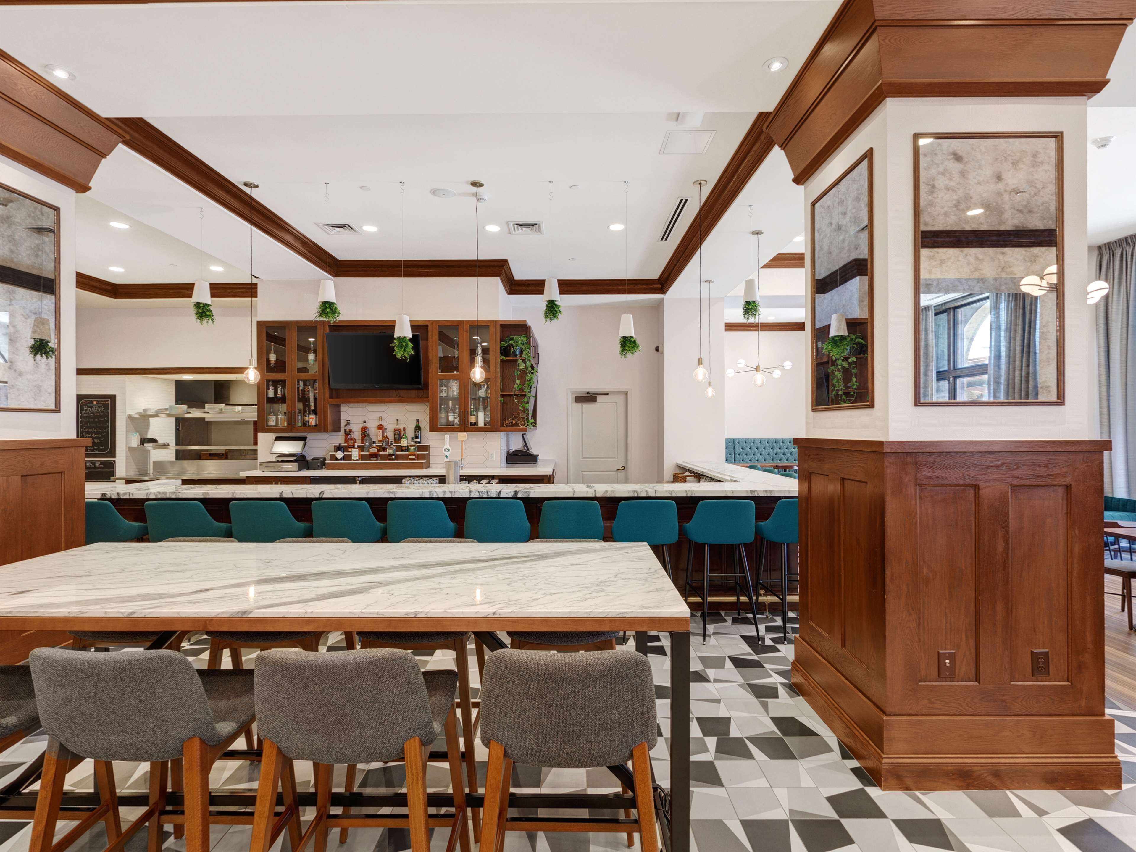 A modern kitchen with a marble island, bar area, and seating.