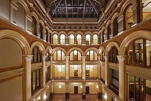 A grand atrium with multiple levels, ornate columns, and a glass ceiling. - Hilton Garden Inn Milwaukee Downtown (Milwaukee)