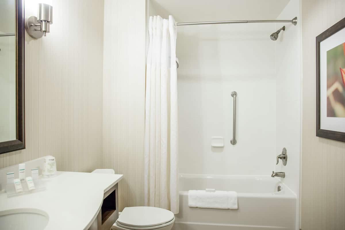 Un baño moderno con un lavamanos, inodoro y ba ñera blancos.