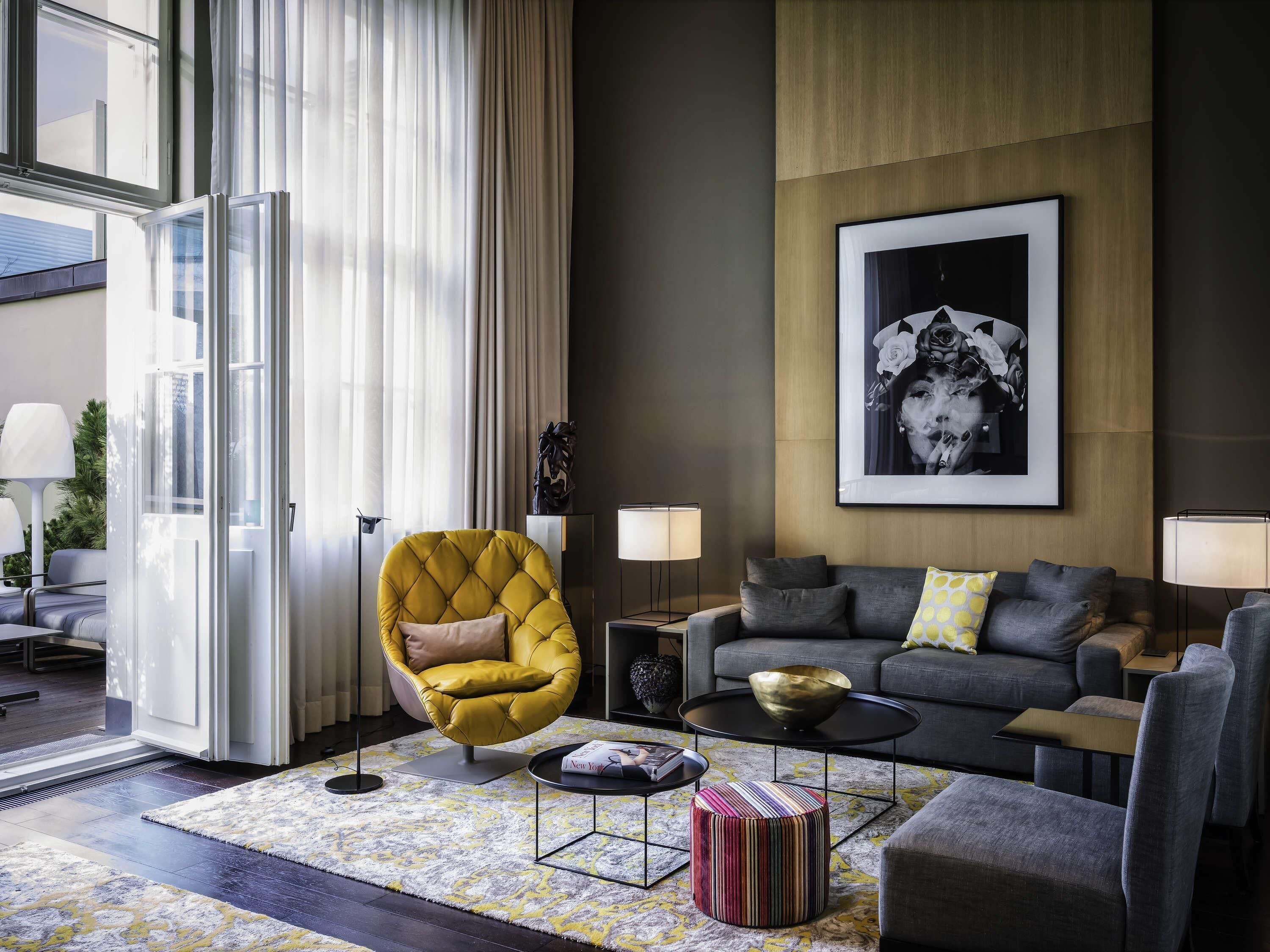 Un salon moderne avec un canapé, des fauteuils, une table basse et un tapis.