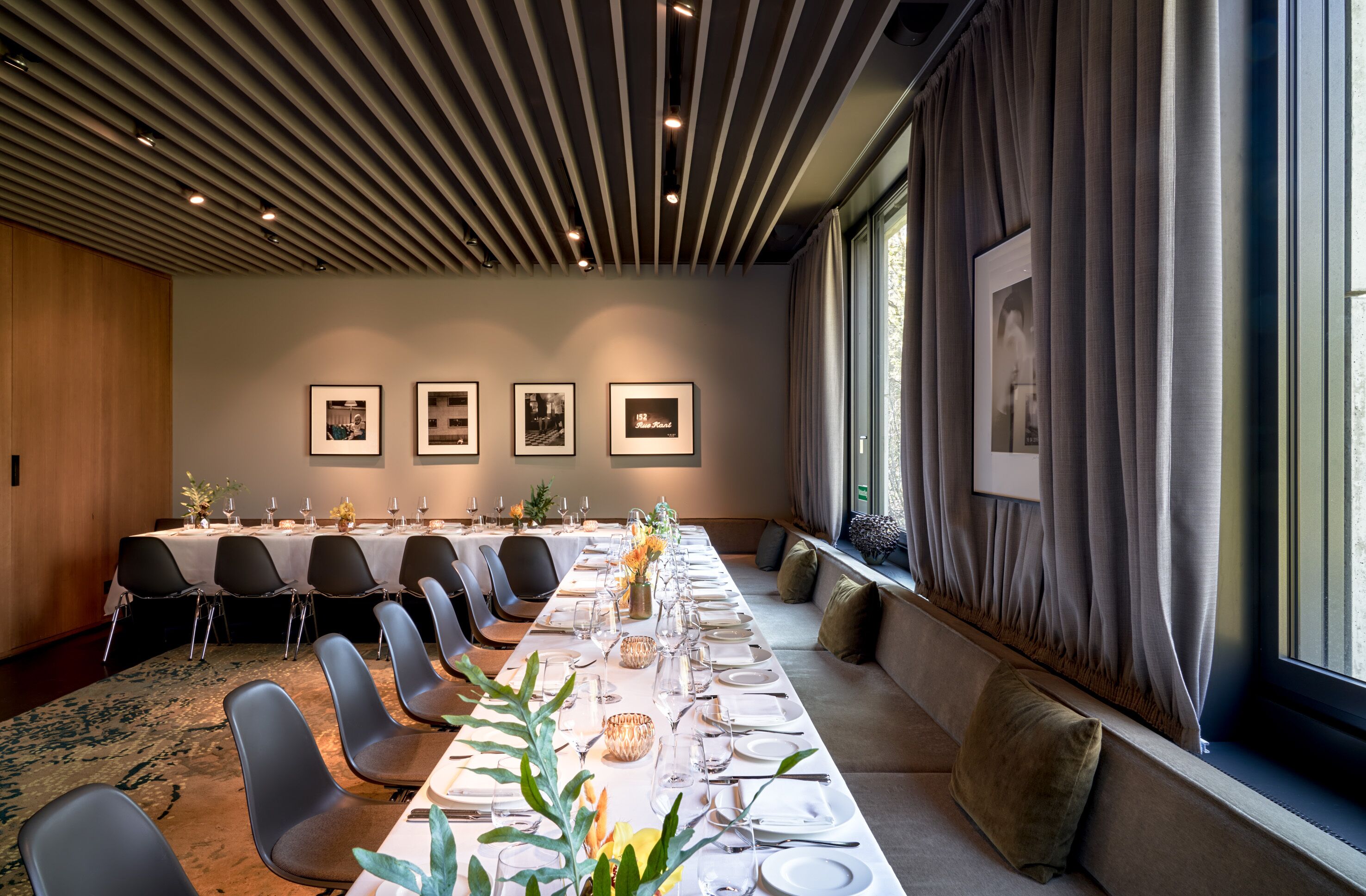 A conference room with a long table set for a meeting, equipped with chairs and a projector screen.