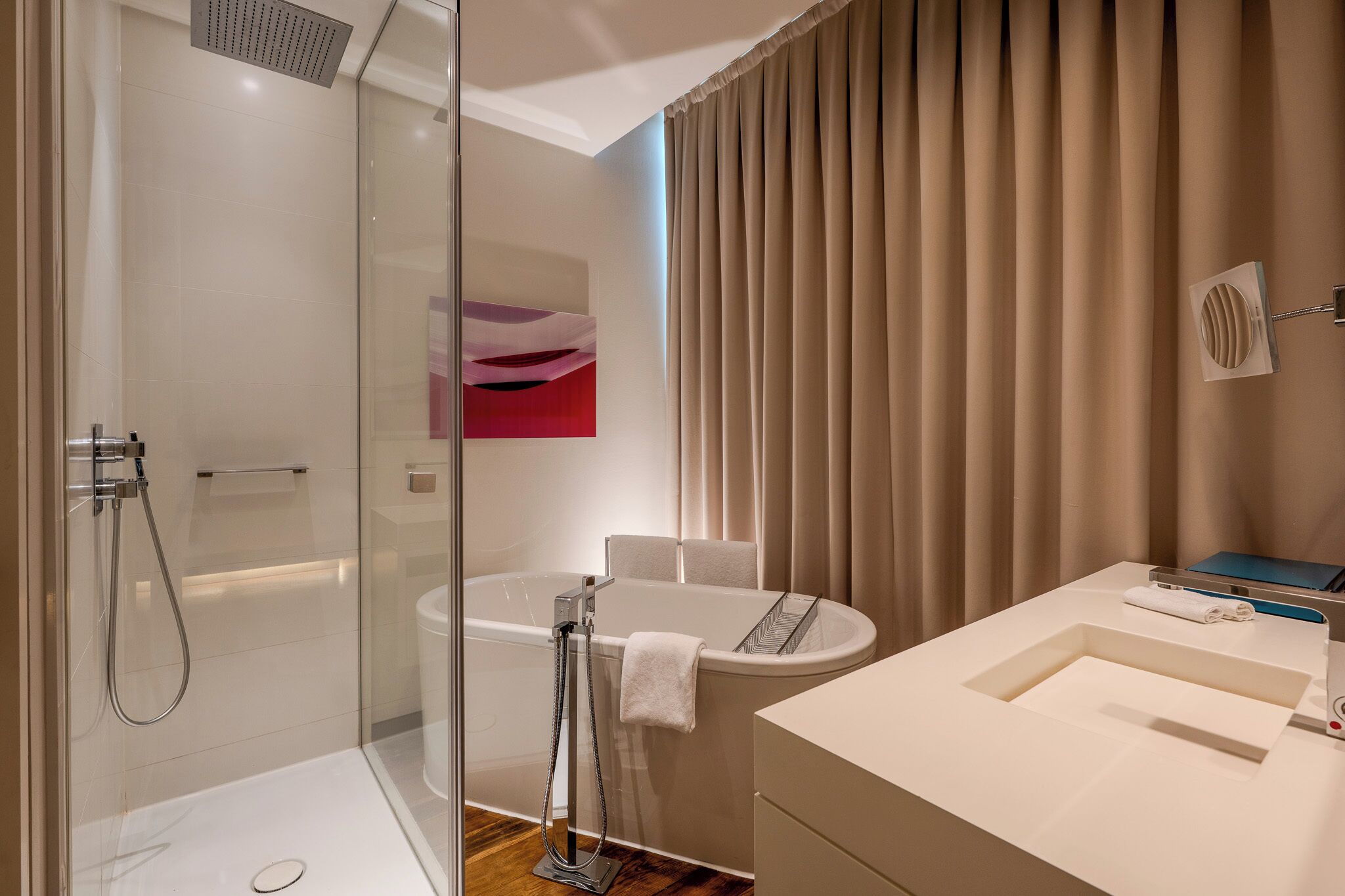 A modern bathroom with a glass-enclosed shower, a standalone bathtub, and a vanity with a sink.